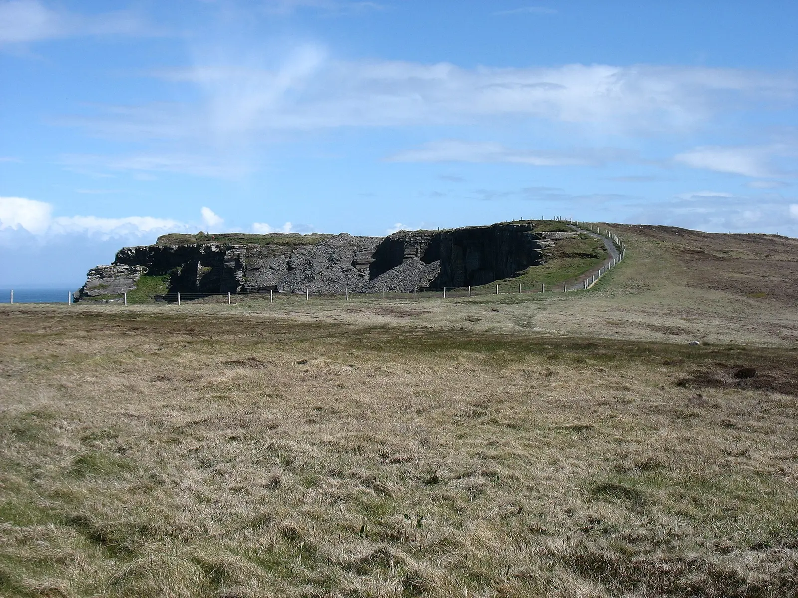 Walking trail tracing the green top of the Cliffs of Moher