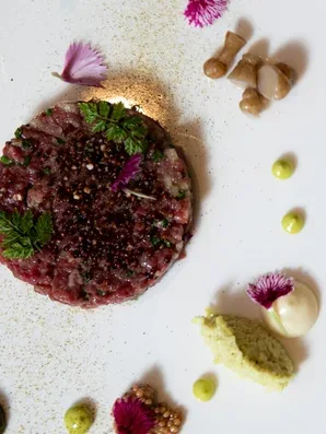 Plated tartare with herbs, edible flowers, and purée from the farewell tasting menu